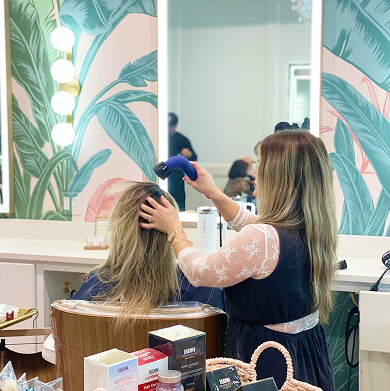 Stylist blow drying hair